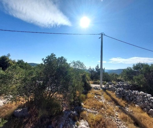 Tágas építési telek vonzó elhelyezkedéssel Trogir közelében, amely ideális befektetésre és fejlesztésre